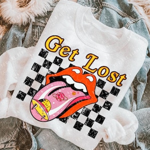 May include: White t-shirt with a black and white checkered background. The text "Get Lost" is in yellow letters. A red tongue with a pink inside and a space-themed design is on the shirt.