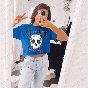 May include: A blue cropped t-shirt with a skull graphic and the text "Elder Emo Society".
