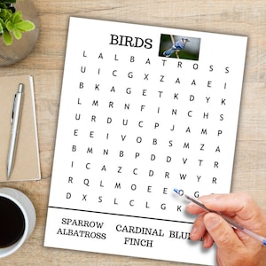 K&ouml;nnte beinhalten: Ein Wortsuchr&auml;tsel mit dem Wort "BIRDS" oben. Das R&auml;tsel zeigt ein Gitter aus Buchstaben mit den W&ouml;rtern Sparrow, Albatross, Cardinal, Bluebird und Finch, die darin versteckt sind. Ein Bild eines Blauh&auml;hers befindet sich in der oberen rechten Ecke.