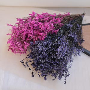 Peut inclure: Deux bouquets de fleurs séchées, l'un magenta vif et l'autre violet foncé. Les fleurs ont de petites fleurs délicates et sont attachées avec de la ficelle. Les tiges sombres contrastent avec les fleurs colorées.