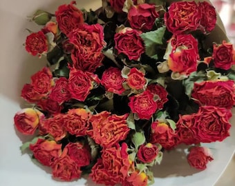 Könnte beinhalten: Ein Strauß getrockneter roter Rosen mit grünen Blättern. Die Rosen sind dicht beieinander und haben eine strukturierte Optik. Der Strauß ist in weißes Papier gewickelt. Der Text "01#" ist oben rechts sichtbar.