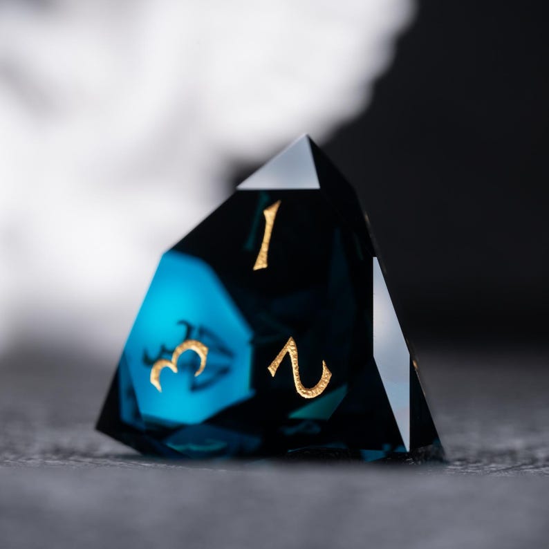 May include: A blue and black gemstone dice with gold numbers 1, 2, and 3.