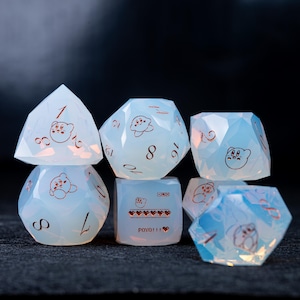 May include: A set of seven opalescent dice with a cartoon character design. The dice are various geometric shapes, including a pyramid, a cube, and a multi-sided die. Each die has a different number and character illustration. The text "POYO!!!" is on one die.