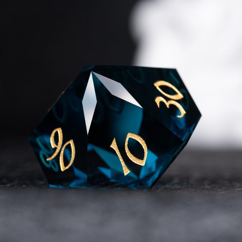 May include: A blue, faceted, crystal d20 dice with gold numbers. The numbers 10 and 30 are visible.