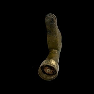 May include: A brass garden hose nozzle shaped like a bird's head. The nozzle is worn and has a patina finish.