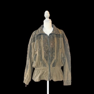 May include: A vintage olive green jacket with a zip-up front, elastic waist, and decorative panels. The jacket is displayed on a mannequin against a black background. The jacket has a high collar and long sleeves.