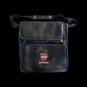 May include: Black PlayStation Underground shoulder bag with a flap closure and a front pocket. The bag features a red and white PlayStation Underground logo. It has a black adjustable shoulder strap.