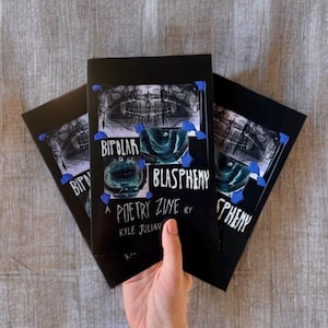 May include: Three black zines titled "Bipolar Blasphemy" are displayed. The cover art features a dental X-ray and a teal-colored design. The text "A Poetry Zine by Kyle Julian" is also visible.