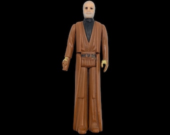 May include: A vintage Star Wars action figure of Obi-Wan Kenobi, wearing a brown robe and a black belt. He has a white beard and a grey face.