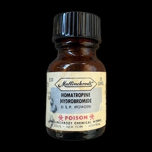 May include: A small amber glass bottle with a black ribbed screw cap. The off-white label features the text Mallinckrodt, Homatropine Hydrobromide, U.S.P. (Powder), 15 Grns, and Poison with red skull and crossbones icons, plus location details.