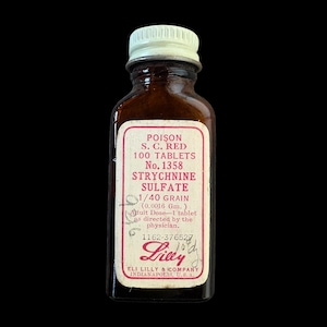 May include: A vintage amber glass bottle with a white screw-top lid. The label reads: POISON S. C. RED 100 TABLETS No. 1358 STRYCHNINE SULPHATE 1/40 GRAIN (0.0016 Gm.) Adult Dose-1 tablet as directed by the physician. Eli Lilly & Company Indianapolis, U.S.A.