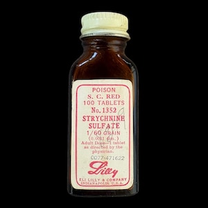 May include: A vintage amber glass bottle with a white metal screw cap and a rectangular label. The label reads: POISON S. C. RED 100 TABLETS No. 1352 STRYCHNINE SULFATE 1/60 GRAIN (0.0011 Gm.) Adult Dose-1 tablet as directed by the physician. 0077-471622 Lilly.