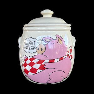 Può includere: Barattolo per biscotti in ceramica color crema con coperchio e manici. Il barattolo presenta un maiale dei cartoni animati con una sciarpa a scacchi rossi e bianchi. Il testo sopra il maiale recita: "Non riesco a credere di aver mangiato l'intero barattolo!"