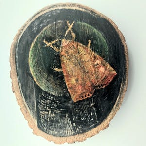 May include: A round, wooden art piece featuring a moth painted on a tree slice. The moth is brown and orange, set against a dark green and black background. The wood slice has a natural, unfinished edge.