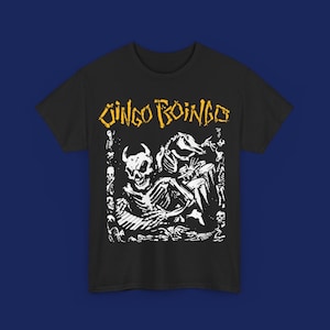 Puede incluir: Camiseta negra con un estampado gr&aacute;fico blanco de un esqueleto con un cr&aacute;neo y cuernos. El texto "Jingo Boingo" est&aacute; impreso en amarillo sobre el gr&aacute;fico.