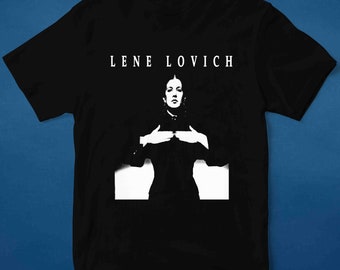 May include: Black t-shirt with a white graphic of a woman with dark hair and a white collar. The text "LENE LOVICH" is printed above the graphic.