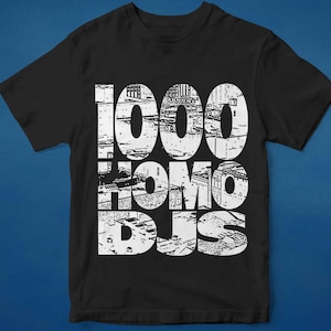 Può includere: T-shirt nero con una stampa grafica bianca del testo "1000 Homo DJs" in uno stile usurato.