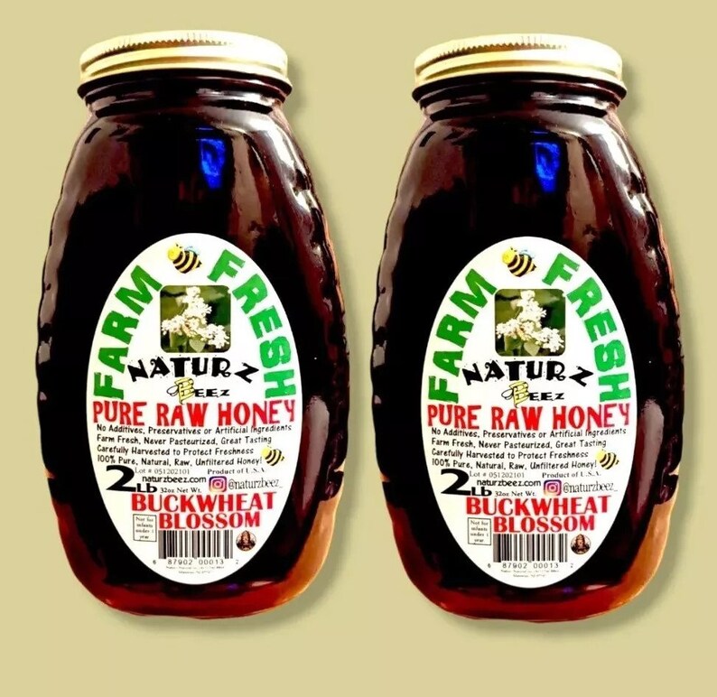Peut inclure: Deux pots en verre de miel de sarrasin en fleurs cru pur de 2 lb. Les pots sont &eacute;tiquet&eacute;s "Farm Fresh Naturz Beez Pure Raw Honey" avec une &eacute;tiquette verte et blanche. Le miel est de couleur ambre fonc&eacute;.