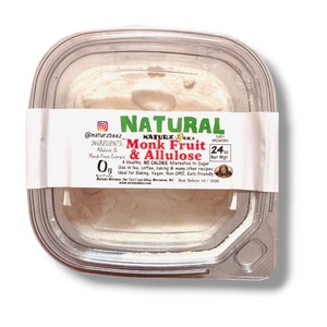 May include: A clear plastic container with a white powder inside. The label reads "NATURAL Monk Fruit & Allulose" with the text "A Healthy, NO CALORIE Alternative to Sugar. Use in tea, coffee, baking & many other recipes. Ideal for Baking, Vegan, Non-GMO, Keto Friendly." The label also includes the text "24 oz Net Wt."