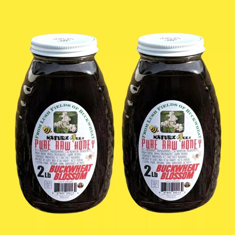 Peut inclure: Deux pots en verre de miel de fleurs de sarrasin cru de 900 grammes. Les pots ont des couvercles blancs et des &eacute;tiquettes qui indiquent "From Lush Fields of Buckwheat, Naturz Beez, Pure Raw Honey, No Additives, Preservatives or Artificial Ingredients, Carefully Harvested to Protect Freshness, Packed Pure for Purity, Not Pasteurized, 100% Pure Unfiltered Raw Honey, 2 lb Buckwheat Blossom".