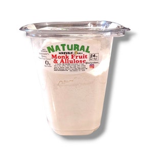 May include: A white plastic container with a white powder inside. The label reads "Natural Monk Fruit & Allulose 24 oz Net Wgt. @naturzbeat".