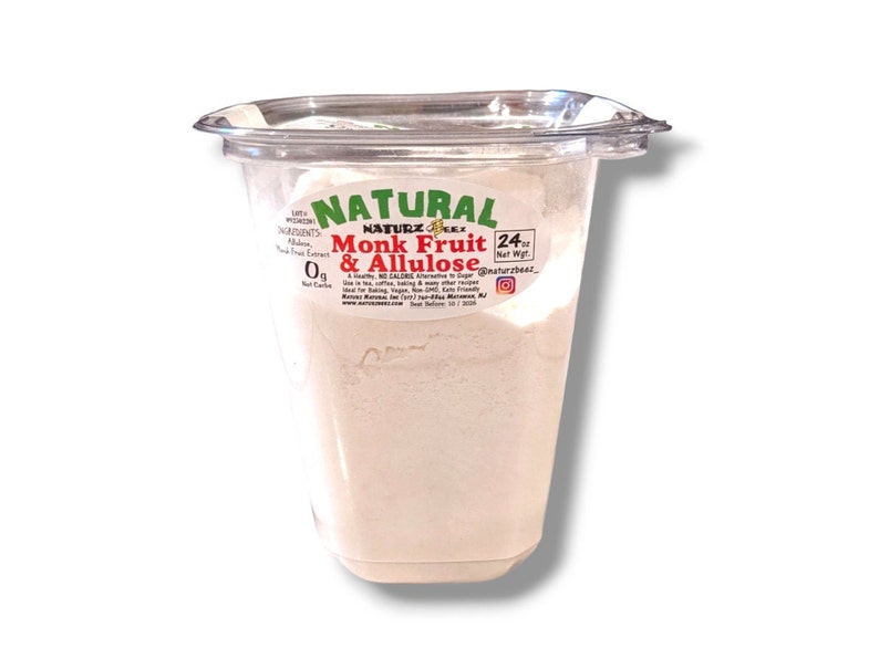 May include: A white plastic container with a white powder inside. The label reads "Natural Monk Fruit & Allulose 24 oz Net Wgt. @naturzbeat".