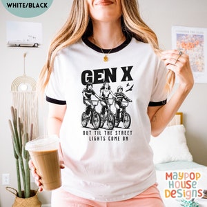 next level ribbed shirt for gen x woman that has three 70s or 80s era kids on bikes and text says gen x out til the street lights come on