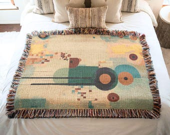 May include: A woven throw blanket with a geometric design featuring circles, squares, and rectangles in shades of green, blue, brown, and yellow. The blanket has a fringe border.