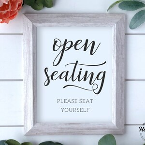 May include: White framed sign with black text that reads "open seating please seat yourself".