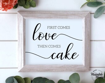 May include: A framed print with the text "First comes love, then comes cake" in a cursive font. The print is on a white background with a black frame.