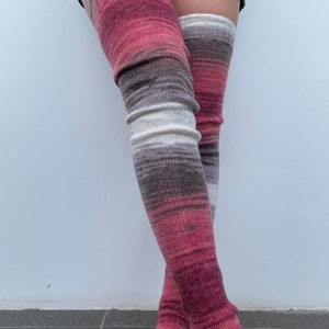 May include: A pair of thigh-high socks with a pink, brown, and white striped pattern.