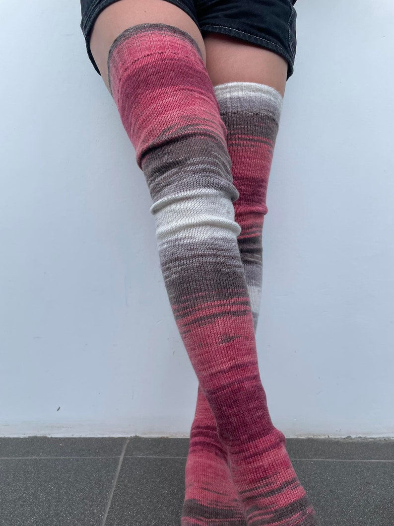 May include: A pair of thigh-high socks with a pink, brown, and white striped pattern.