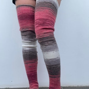 May include: A pair of long, pink, brown, and white striped thigh-high socks.