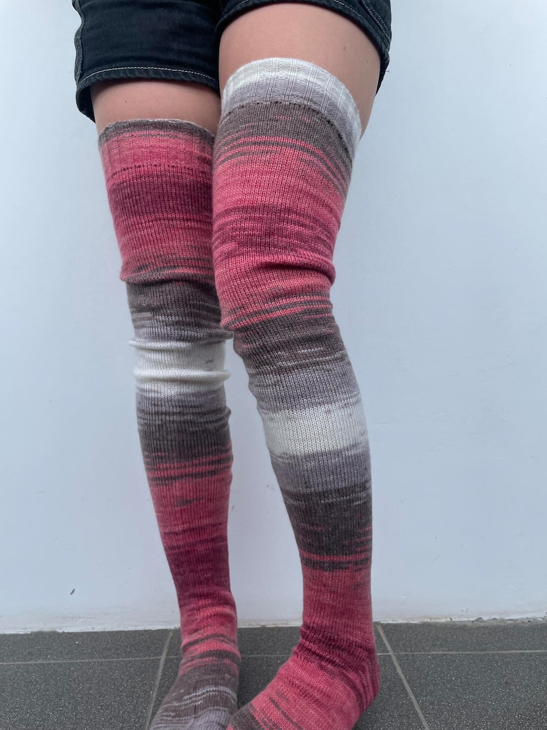 May include: A pair of long, pink, brown, and white striped thigh-high socks.