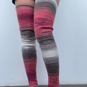 May include: A pair of long, pink, brown, and white striped thigh-high socks.