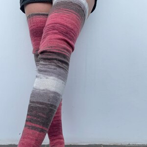 May include: Striped thigh-high socks in shades of pink, brown, and white.