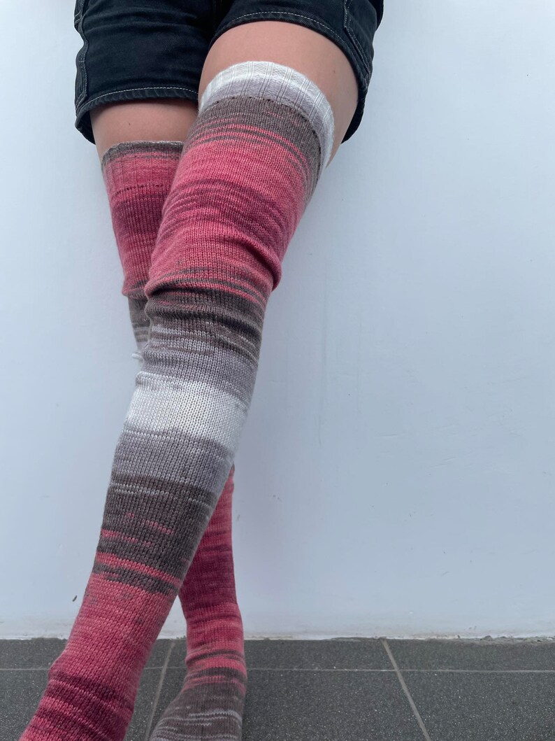 May include: Striped thigh-high socks in shades of pink, brown, and white.