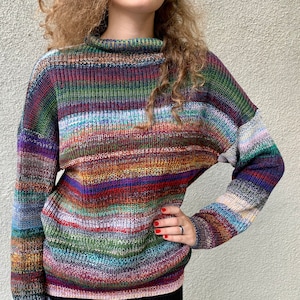 Puede incluir: Suéter de rayas multicolores con cuello alto y mangas largas.
