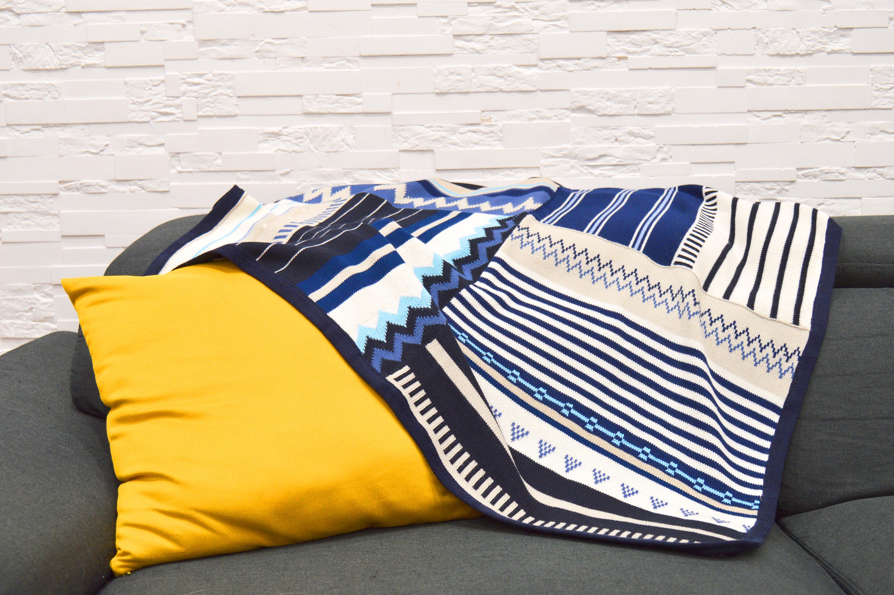 手編みのストライプ模様と装飾のある子供用ブランケット。性別を問わ