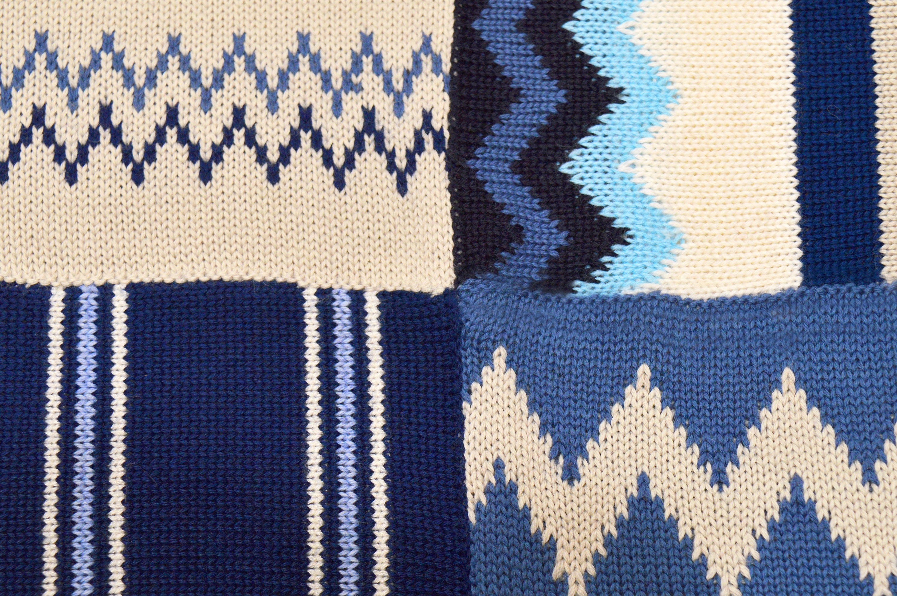 手編みのストライプ模様と装飾のある子供用ブランケット。性別を問わ