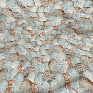 May include: A fabric with a repeating pattern of overlapping seashells. The shells are in shades of white, light blue, and brown, creating a textured, organic design. The overall effect is reminiscent of a beach or ocean theme.