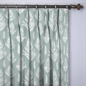 May include: A pair of pleated curtains with a repeating pattern of white fern leaves on a muted teal background. The curtains are hanging from a dark metal rod with decorative finials, adding a touch of elegance to the room.