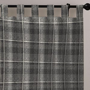 Puede incluir: Un par de cortinas a cuadros grises y blancos colgadas de una barra de cortina negra. Las cortinas tienen un patrón de cuadros clásico, con una cuadrícula repetida de cuadrados grises oscuros y blancos. La tela es texturizada y parece ser un material de peso medio.