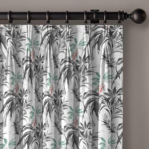 May include: White curtain with a botanical design of grey, black, green, and red leaves and flowers. The curtain hangs from a dark brown metal rod with rings.