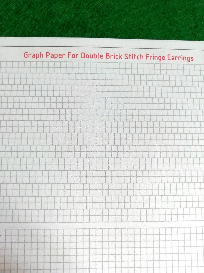 May include: A sheet of white graph paper featuring a grid of rectangular cells designed for double brick stitch fringe earrings. The text Graph Paper For Double Brick Stitch Fringe Earrings is printed in red at the top of the page.