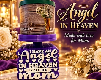 May include: A cylindrical candle with a green lid and a label featuring a wooden background, a gold vase, and white flowers. Below, a purple 3D-printed base displays the white text: I HAVE AN ANGEL IN HEAVEN I CALL HER MOM, surrounded by small white heart icons.