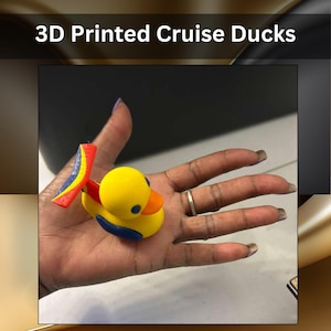 May include: A small 3D printed yellow duck figurine with a bright orange beak, blue eyes, blue wings, and a colorful tail fin featuring red, yellow, and blue stripes. The text 3D Printed Cruise Ducks is displayed above the object.