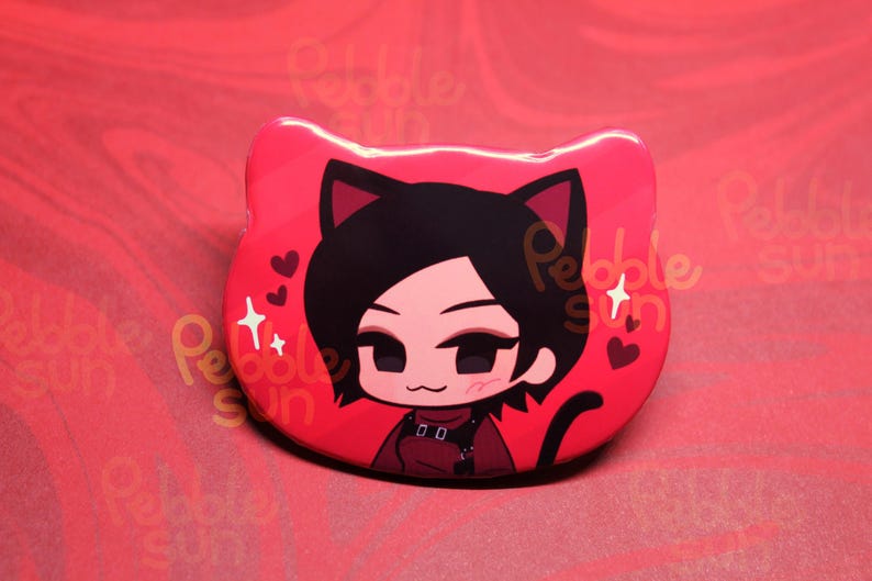 May include: A red, cat-shaped pin featuring a cartoon character with black hair and cat ears. The character is wearing a red outfit and surrounded by hearts and stars. The pin has a glossy finish.