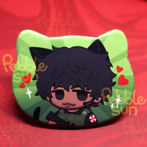 May include: A green cat-shaped button featuring a cartoon character with black hair and cat ears. The character wears a military vest and has a headset. Red hearts and the text "Pebble Sun" are also visible.