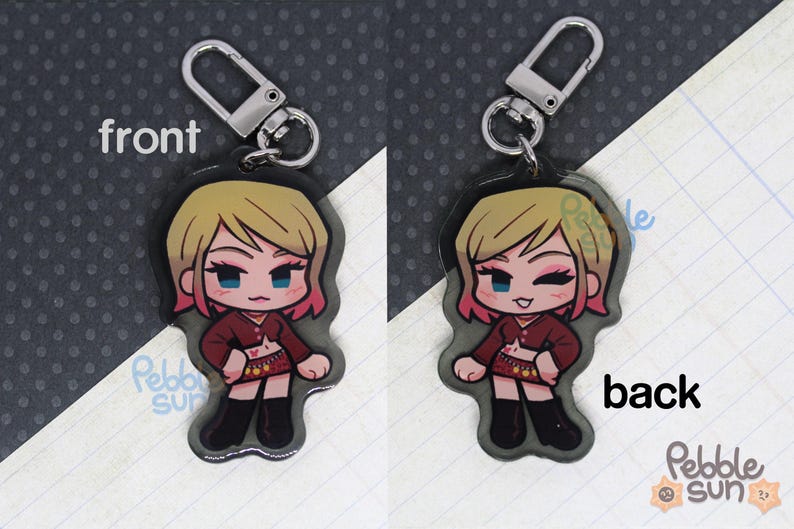 May include: A keychain featuring a cartoon character with blonde hair, wearing a red shirt, a black skirt, and black boots. The keychain is made of clear acrylic and has a silver metal ring.